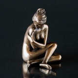 Lady sitting with her arms aroung her, bronze finish