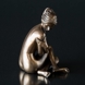 Lady sitting with her arms aroung her, bronze finish