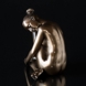 Lady sitting with her head on her knee, bronze finish
