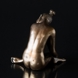Lady sitting with her head on her knee, bronze finish