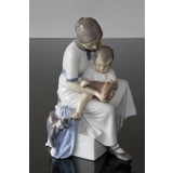 Mother with child taking off sock, Bing & Grondahl figurine