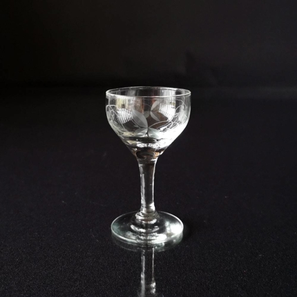 Portweinglas mit Ausschnitten von Blättern und Weintraubenrispen